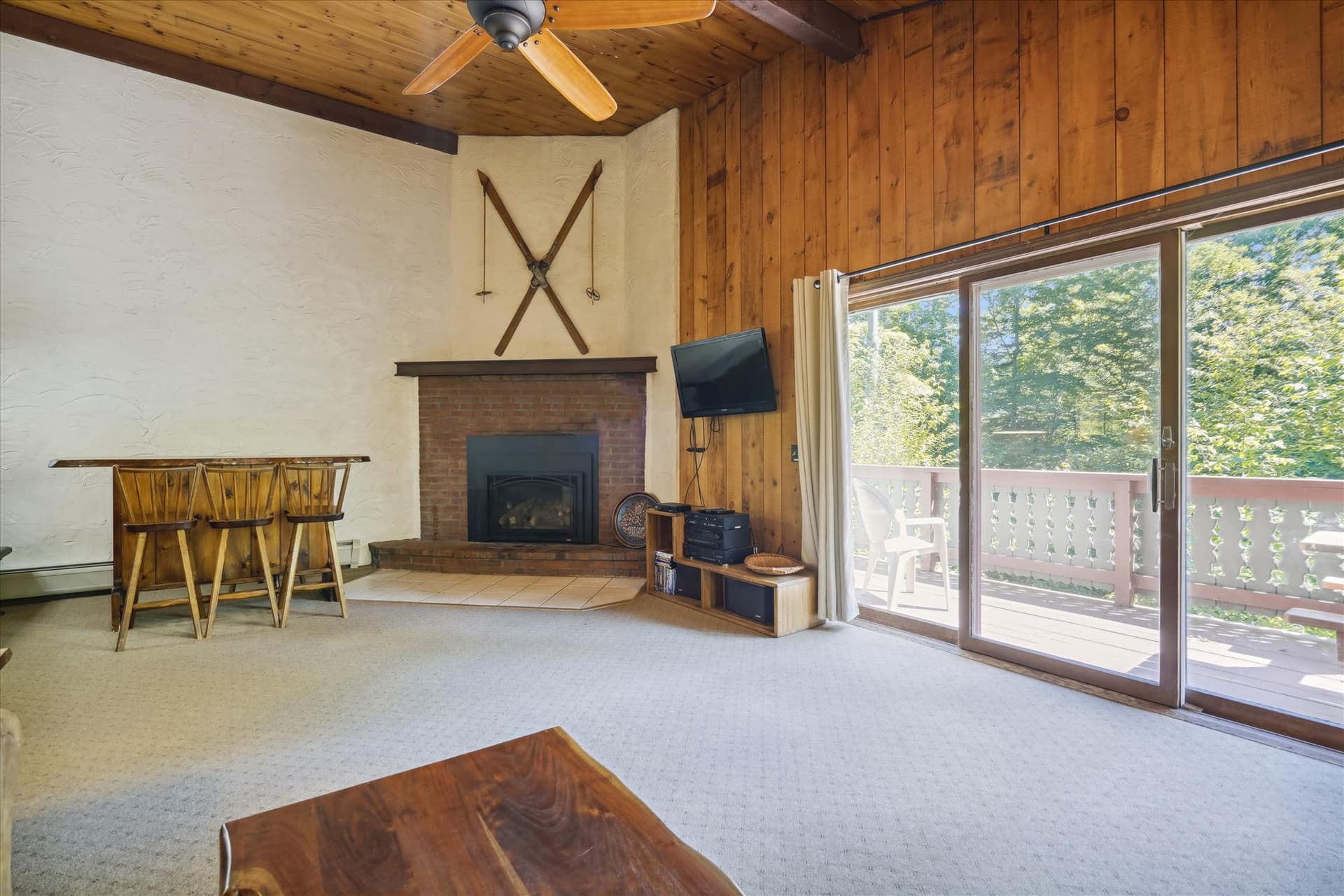 Propane fireplace and seating at small bar and sliding glass doors and decking, for your entertainment.
