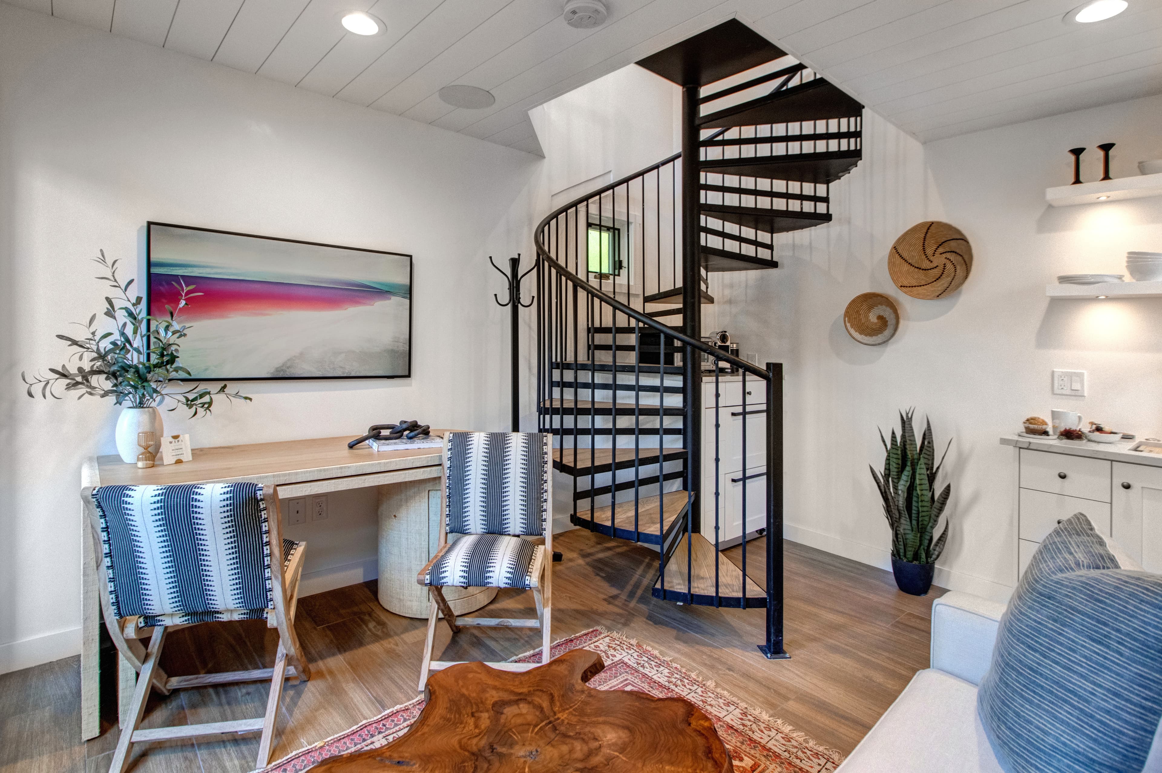 Detached guest suite accessed via the patio. Features a living area with a small kitchenette, TV, a desk and a queen sleeper sofa for additional guests.