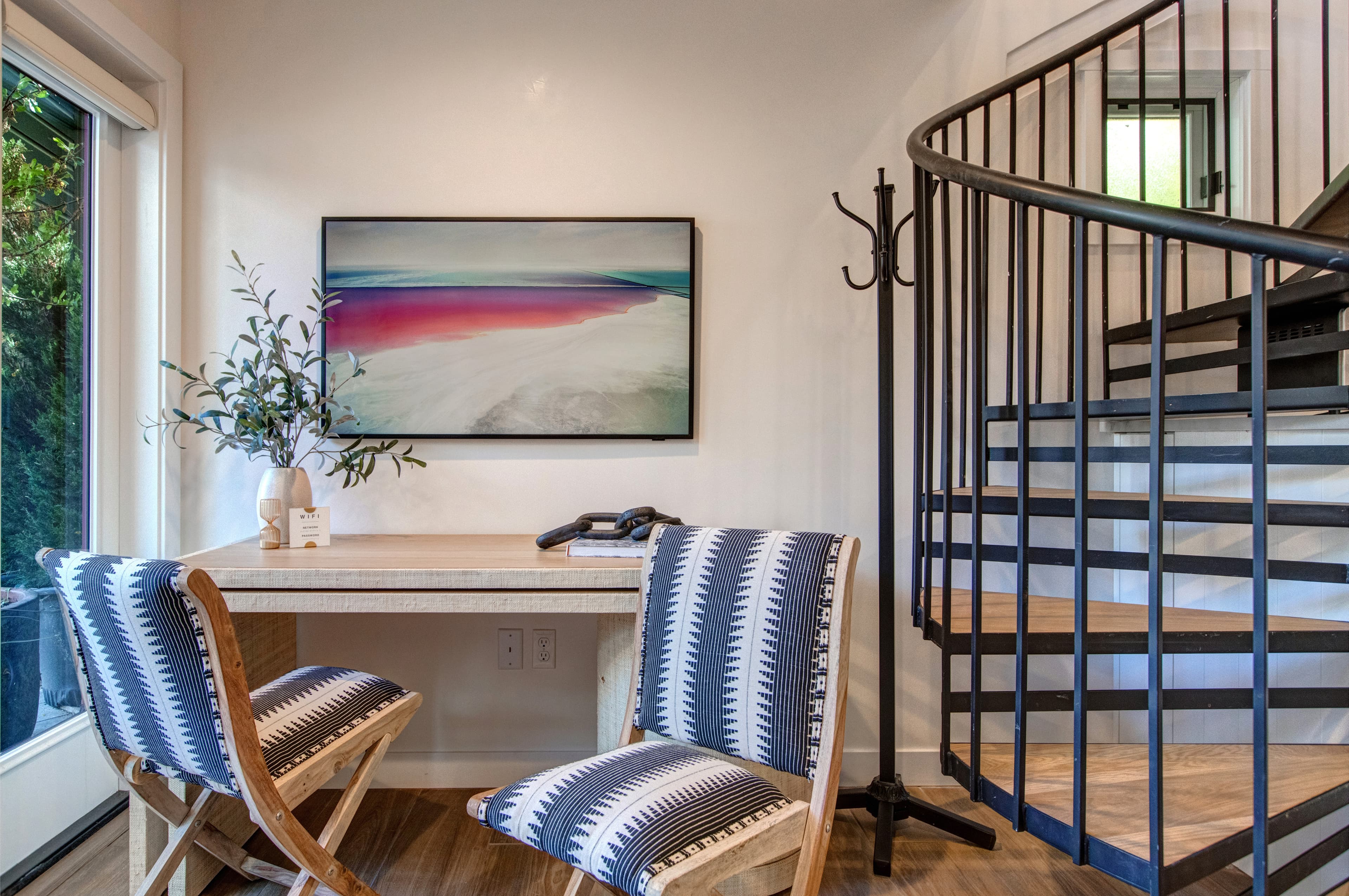Detached guest suite accessed via the patio. Features a living area with a small kitchenette, TV, a desk and a queen sleeper sofa for additional guests.