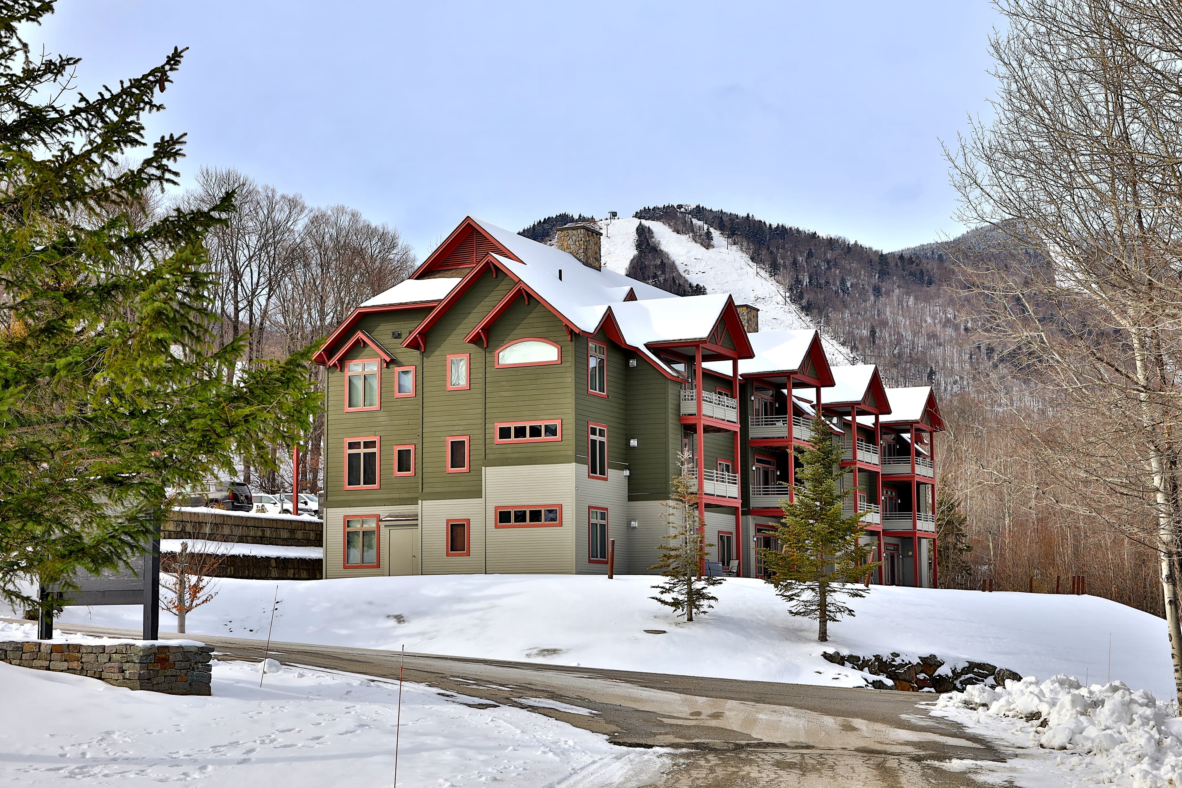 Winter view of The Lodges complex surrounded by mountain scenery. Crisp architecture with easy parking and quick access to nearby trails and resort areas.