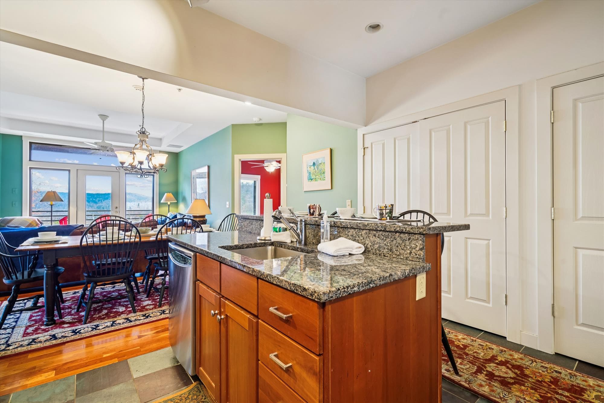 Granite breakfast bar with seating for two, perfect for quick bites or chatting with the cook. A bright, welcoming spot that connects the kitchen to the rest of the living space.