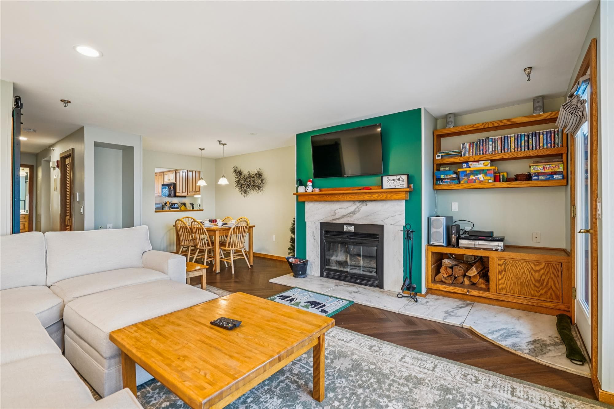 The open living and dining area offers comfortable seating, a cozy fireplace, and a welcoming space to gather after a day on the mountain.