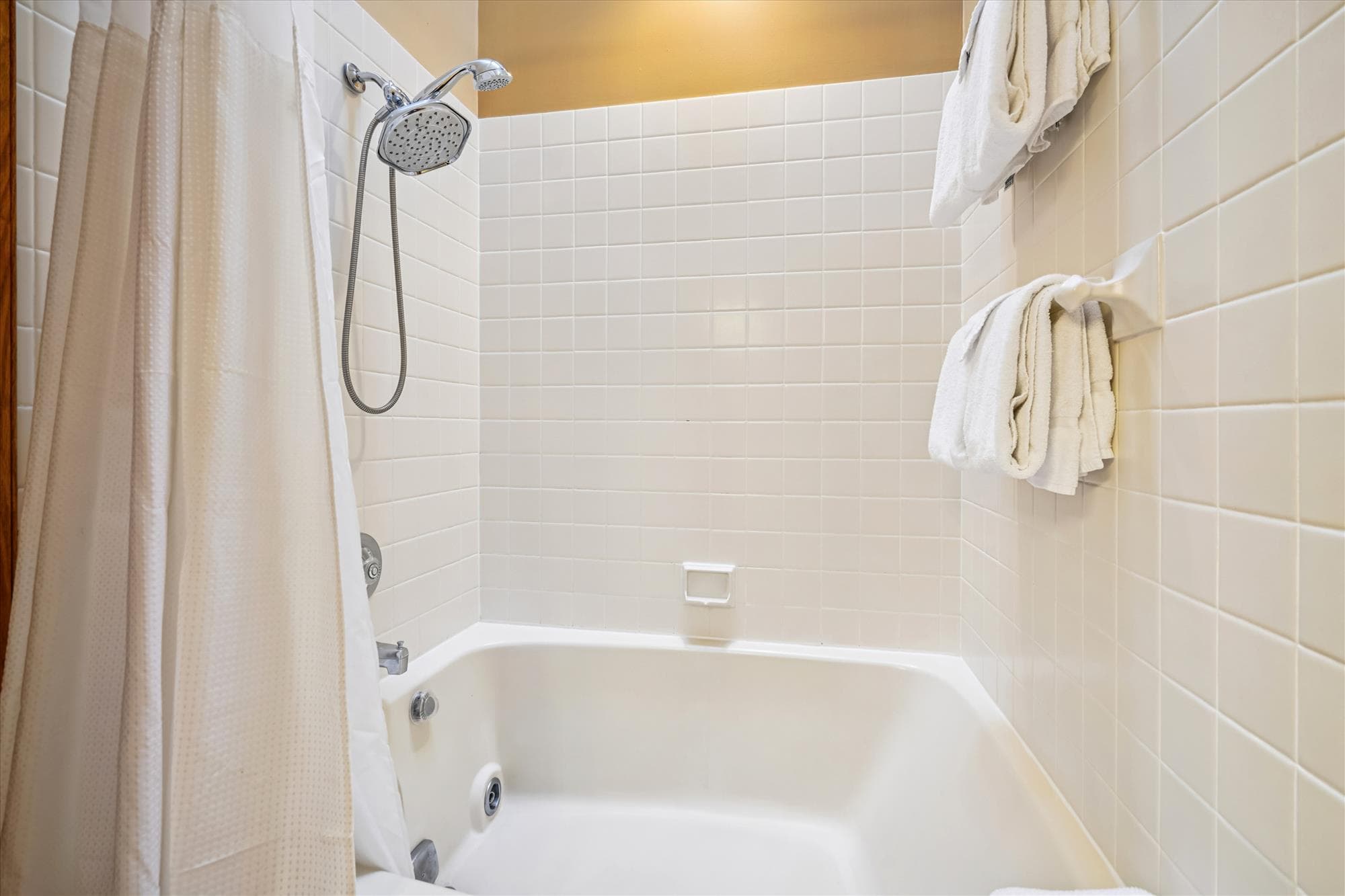 Full bathroom featuring a tub and shower combination with fresh towels provided.
