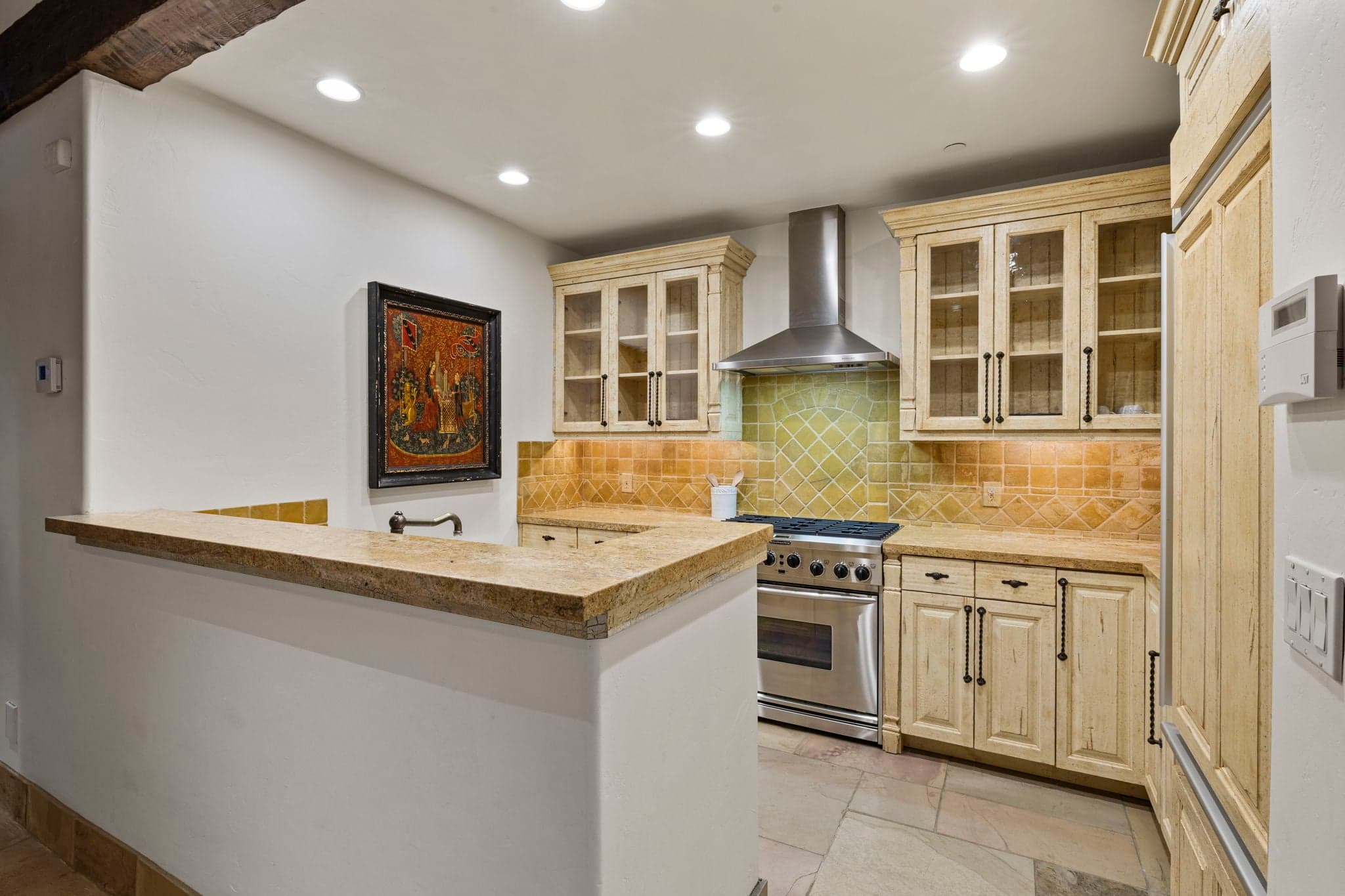 Lower-level gourmet kitchen with stainless steel appliances and custom cabinetry.
