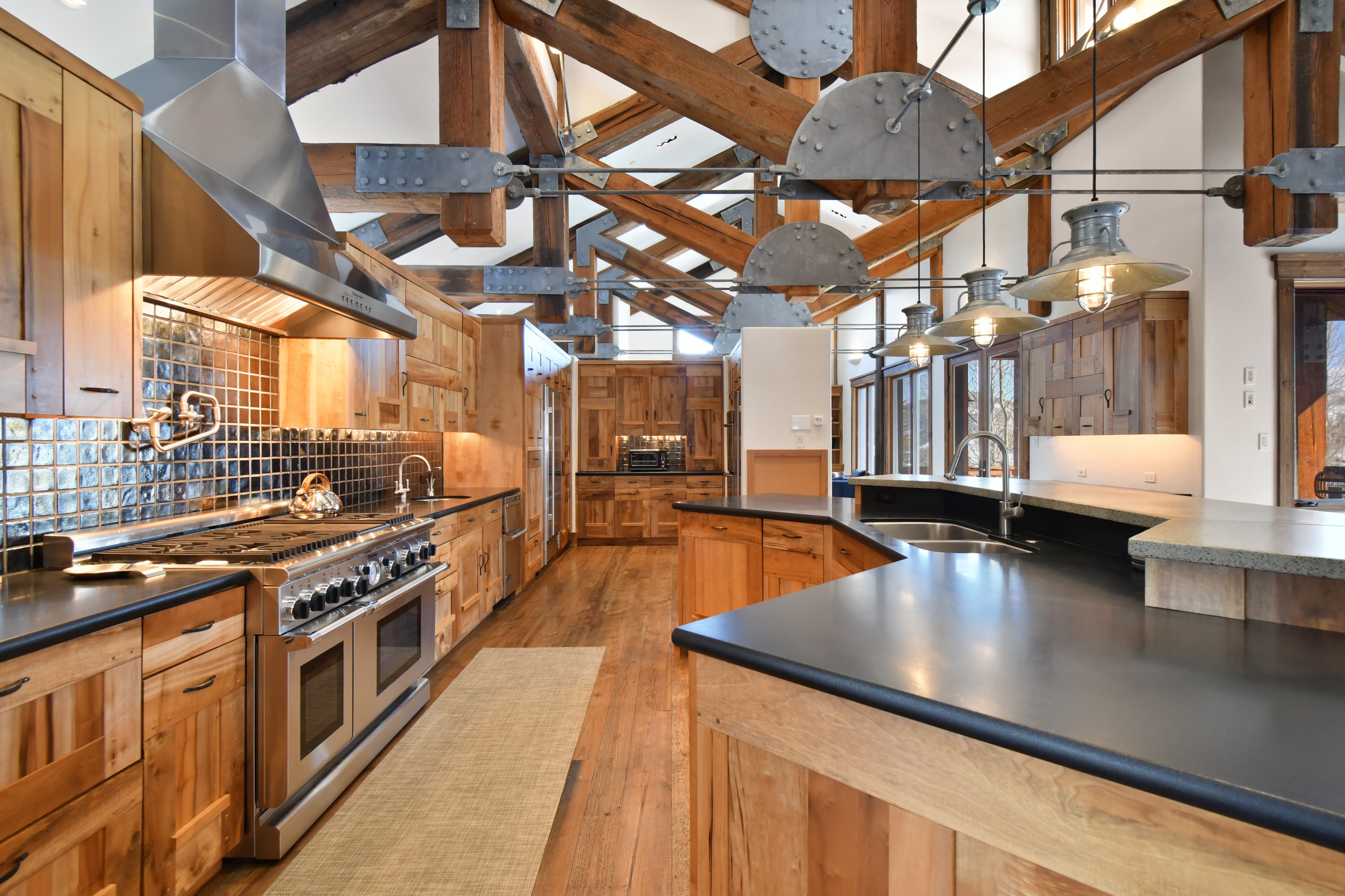 A view into the kitchen highlighting the island (with built in sink) and the wide oven range.