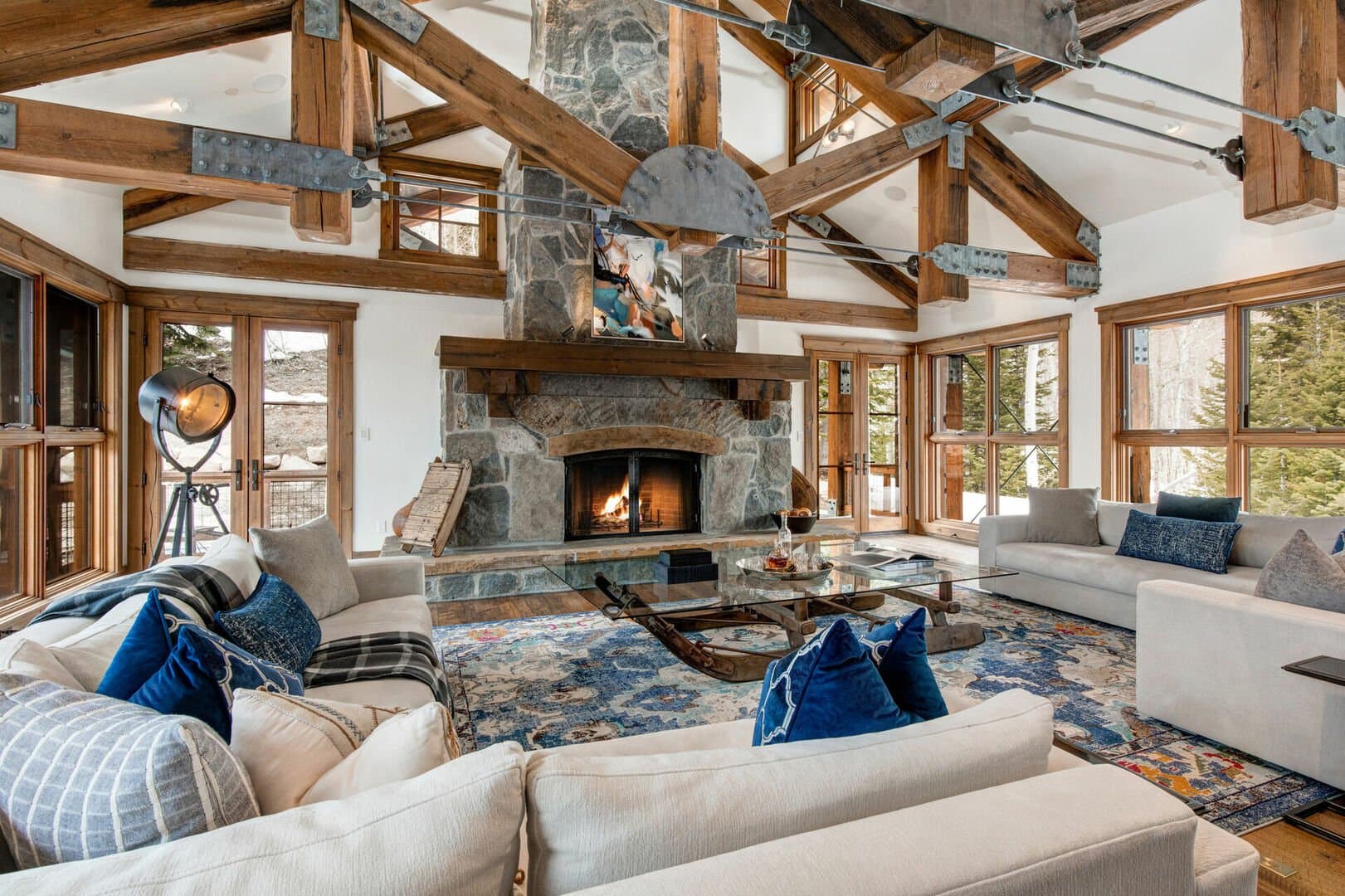 A lit fireplace sits in the center of the living space, surrounded by couches.