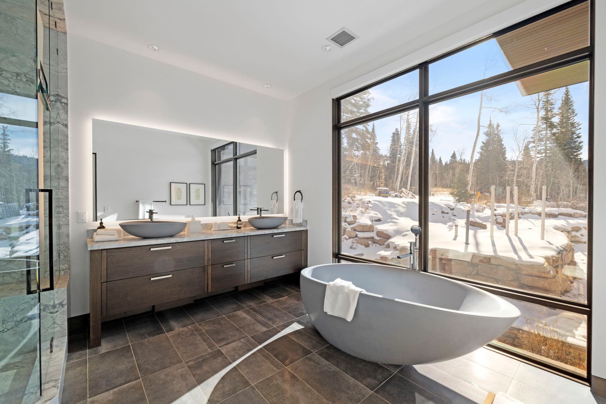 A large bathroom with a modern tub and twin sinks.