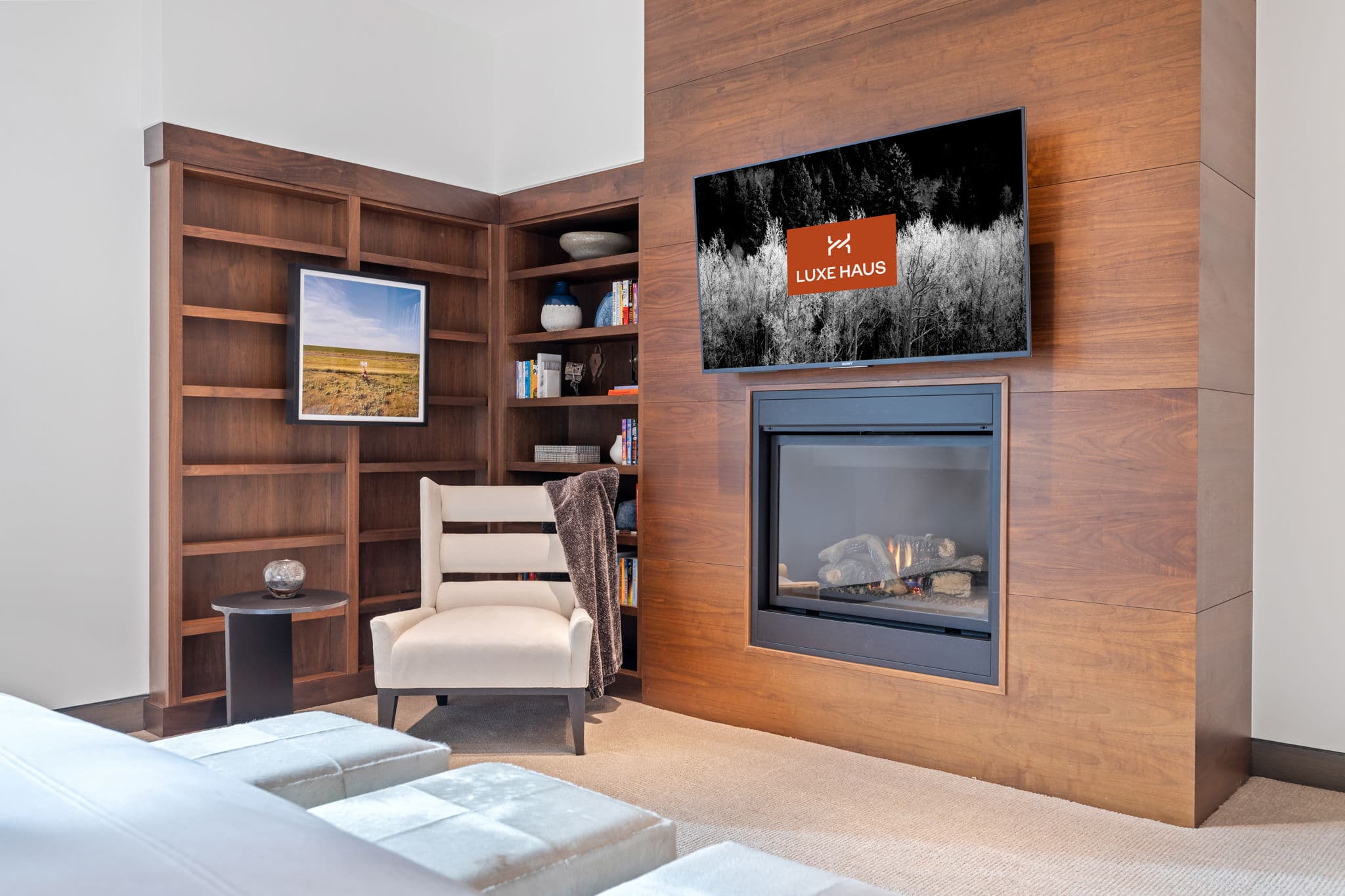 A seating area with a chair, a fireplace, and a flatscreen tv.