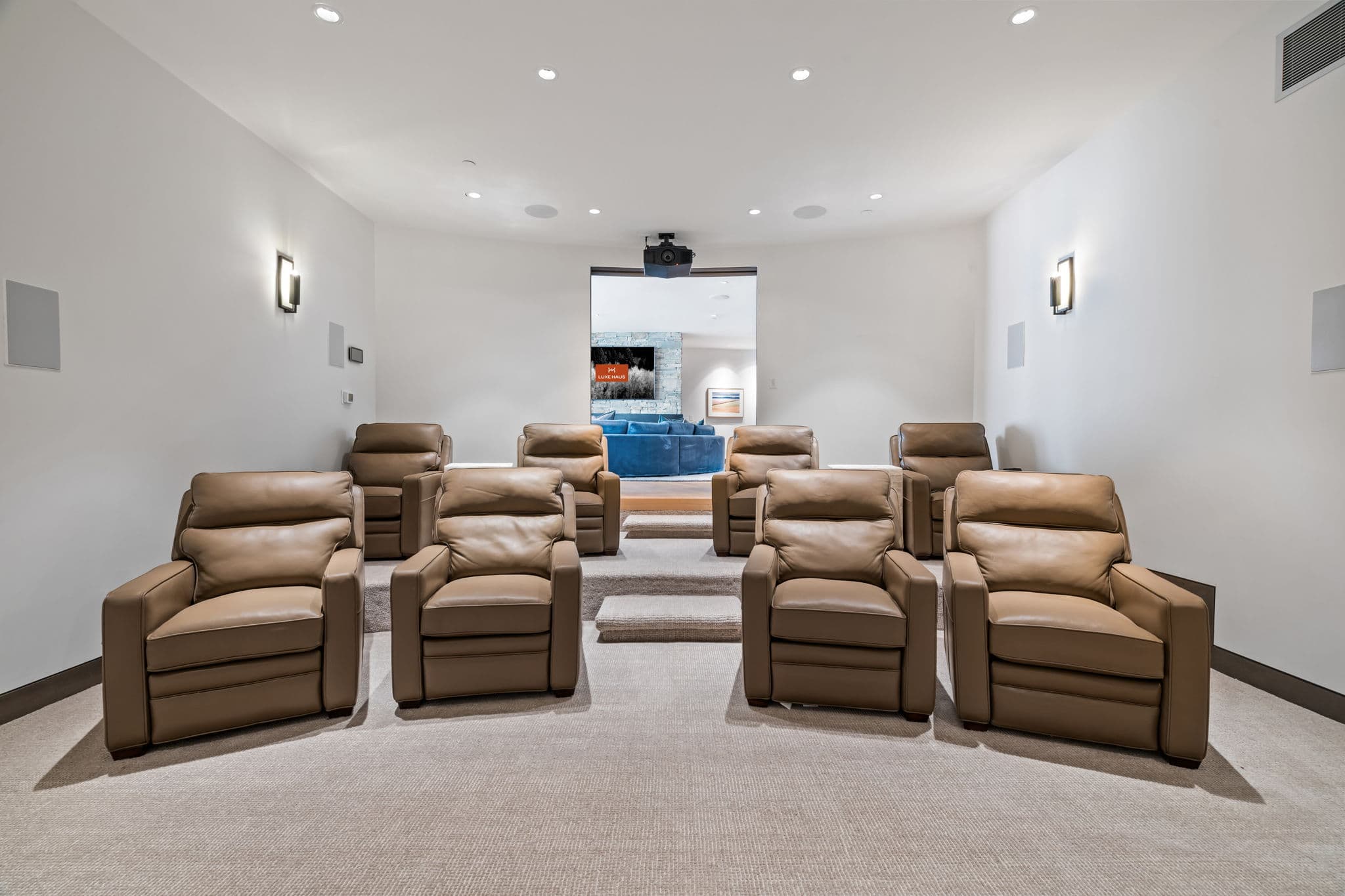 A large theater room with reclining chairs.