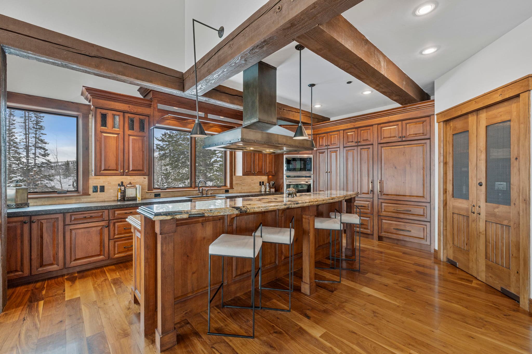 a view of a gourmet kitchen with marble countertops and a view of the mountains