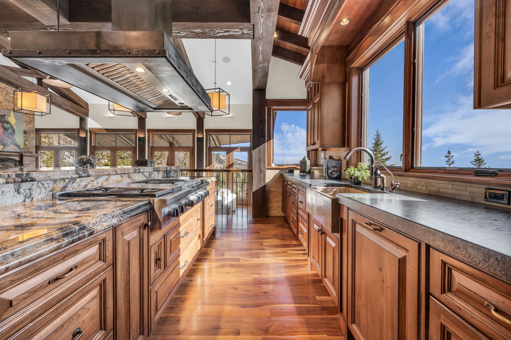 view of kitchen with sink and large windows on one side and stove and marble countertop on left side