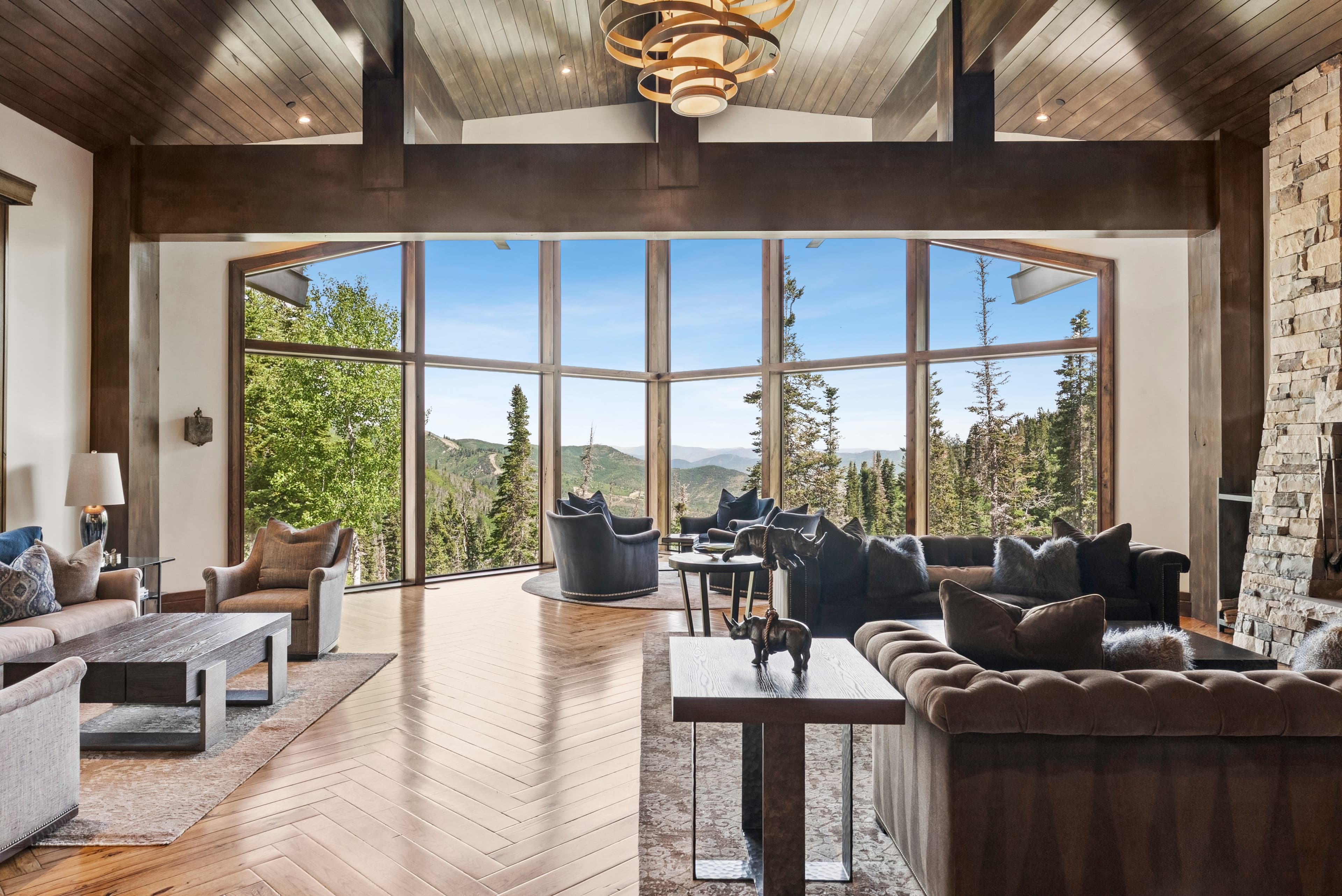 a view staring out the windows of the great room, you can see the mountains and trees with the floor to ceiling windows